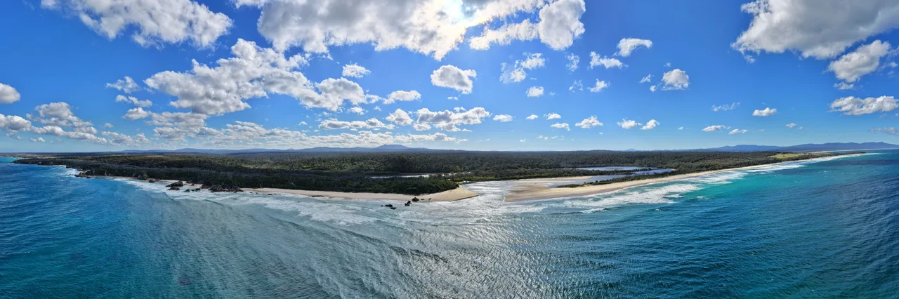 Aerial panorama of Betka Beach, its river mouth and waves rolling along the coast.